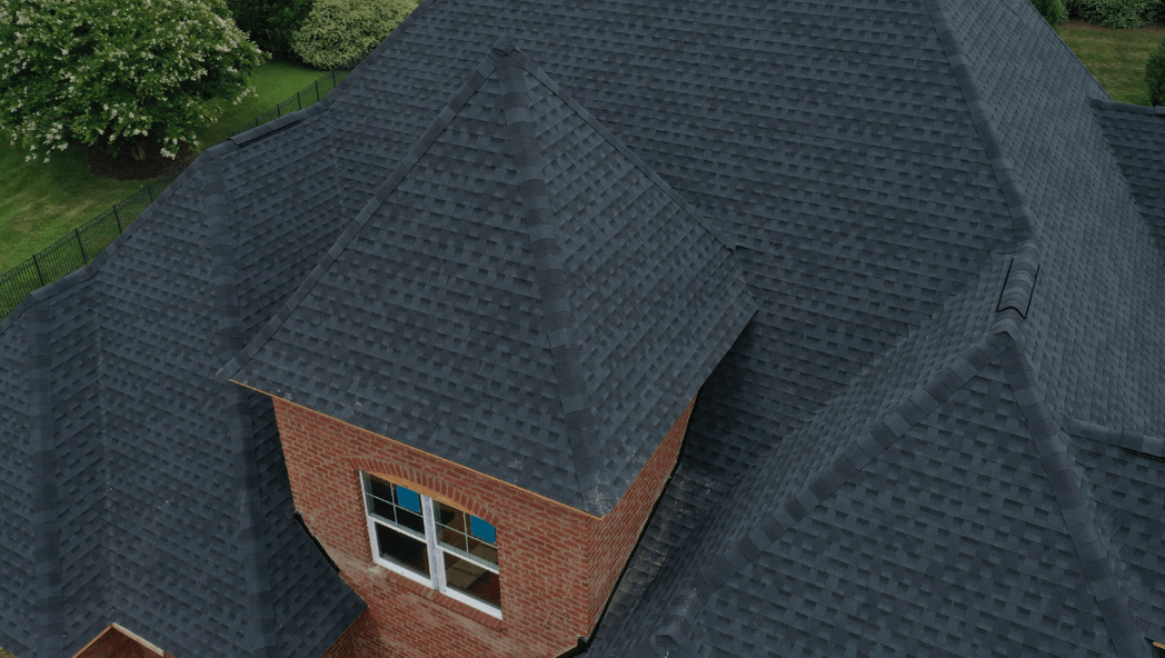 dark gray shingles on a high cathedral roof with several points